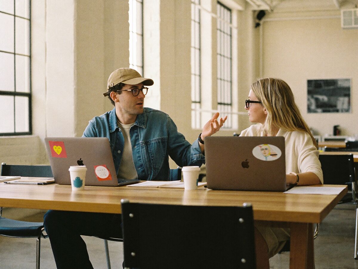 Two specialists working side by side by the studio windows